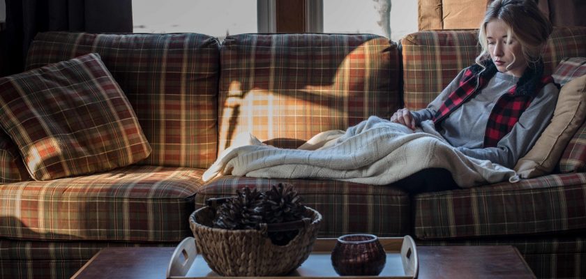 Femme triste coucher sur un divan en hiver
